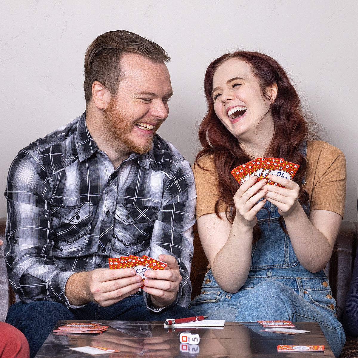 Friends laughing and having fun as they play Oh Crud, the card and dice game.